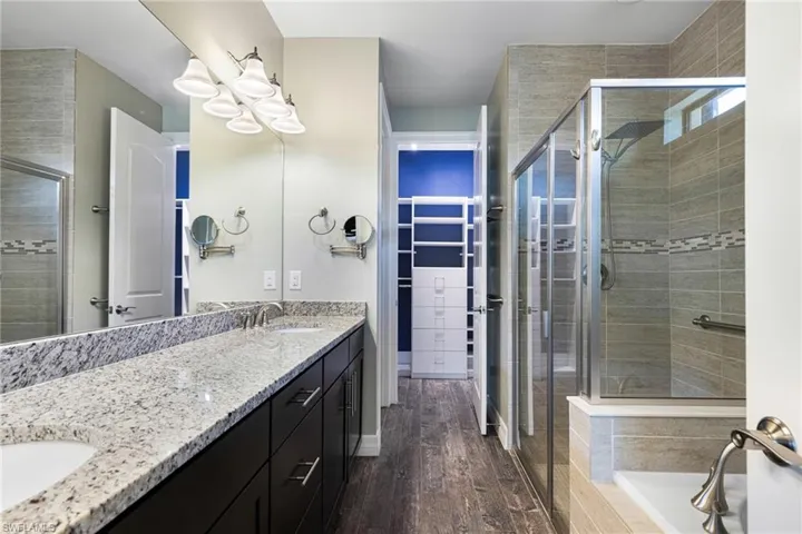 Bathroom with shower with separate bathtub, vanity, and wood-type flooring