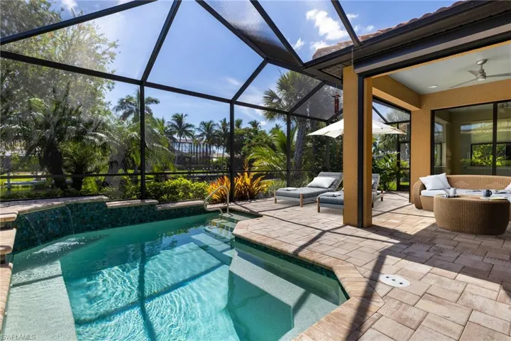 View of swimming pool with ceiling fan, a lanai, pool water feature, a patio area, and an outdoor living space