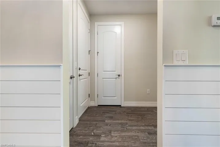 Corridor with dark hardwood / wood-style flooring
