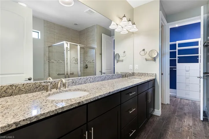 Bathroom featuring vanity, walk in shower, and hardwood / wood-style floors