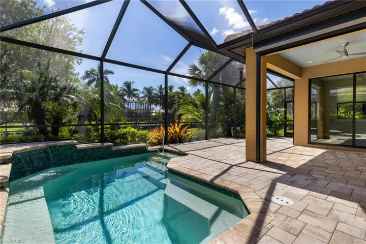 View of swimming pool with a patio area, ceiling fan, a lanai, and pool water feature