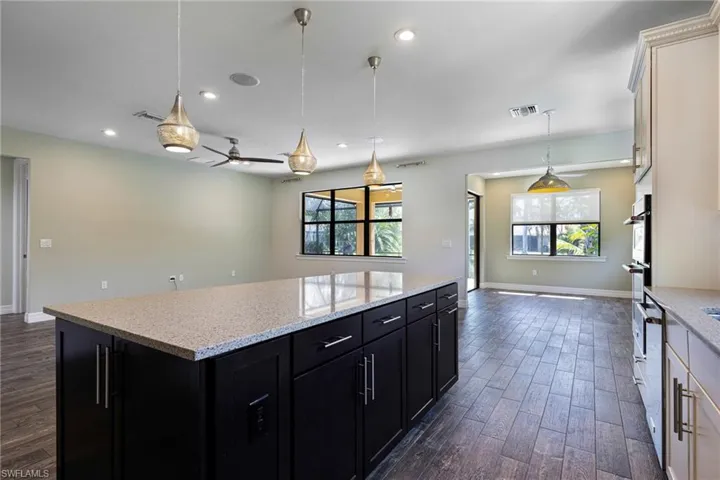 Kitchen featuring dark hardwood / wood-style flooring, decorative light fixtures, plenty of natural light, and ceiling fan