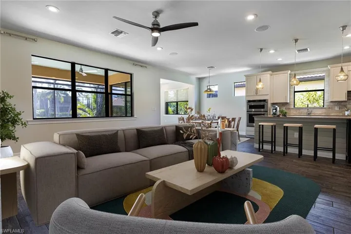 Living room featuring ceiling fan, sink, and dark hardwood / wood-style flooring