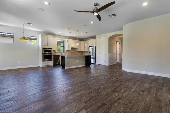 Unfurnished living room featuring dark hardwood / wood-style flooring and ceiling fan