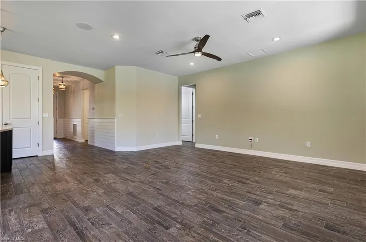 Spare room with ceiling fan and dark wood-type flooring