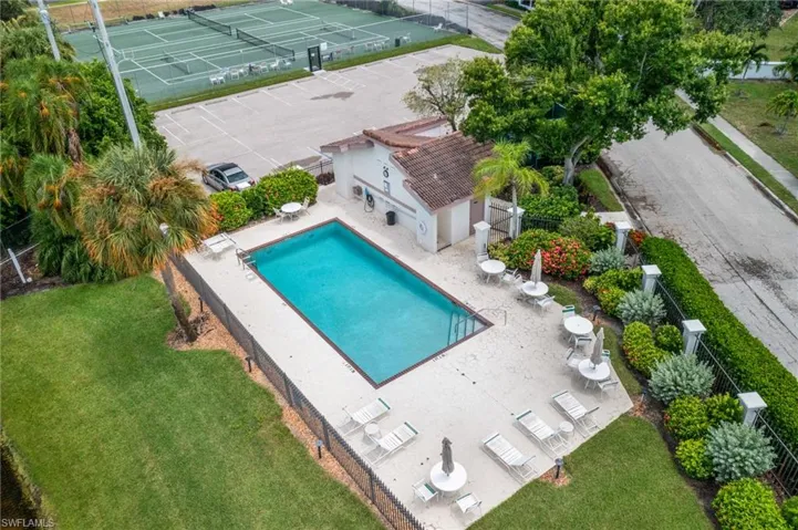 View of pool featuring a lawn, tennis court, and a patio