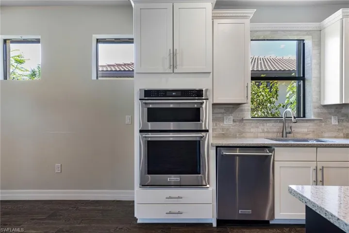 Kitchen featuring sink, plenty of natural light, appliances with stainless steel finishes, and dark hardwood / wood-style floors