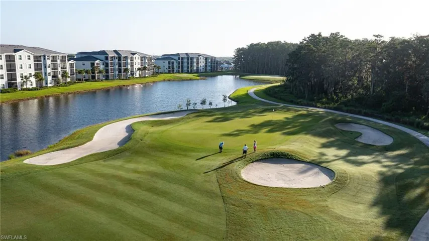 Golf course green with multiple sand traps bordering a body of water