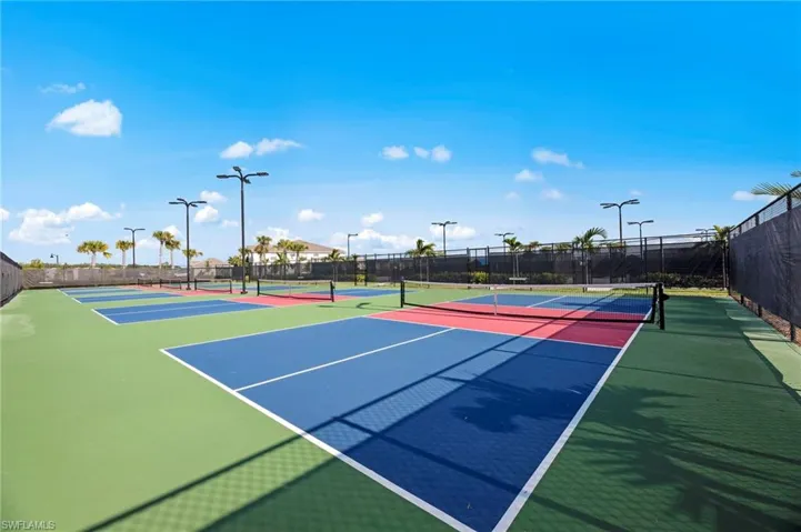 Multiple outdoor pickleball courts featuring blue, red, and green surfaces with white line markings