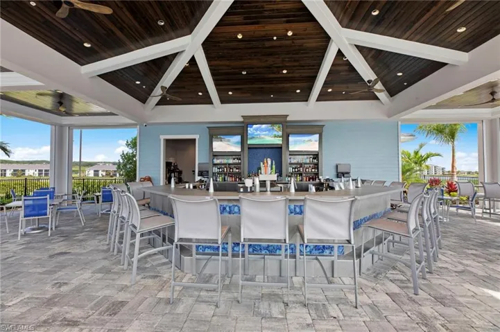 Outdoor bar area featuring a wood-finish vaulted ceiling with exposed beams, recessed lighting, and ceiling fans