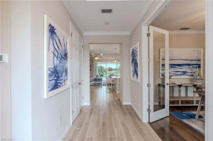 Entryway with wood-finish flooring, crown molding, and recessed lighting
