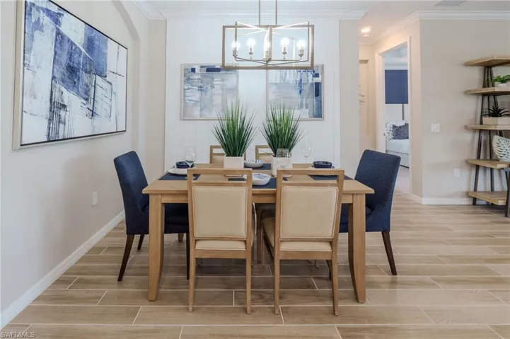 Dining area featuring wood-finish flooring, an arched entryway, and crown molding