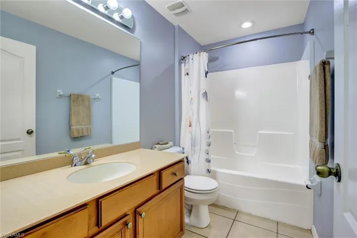 Full bathroom featuring light tile patterned floors, vanity, and shower / bath combo