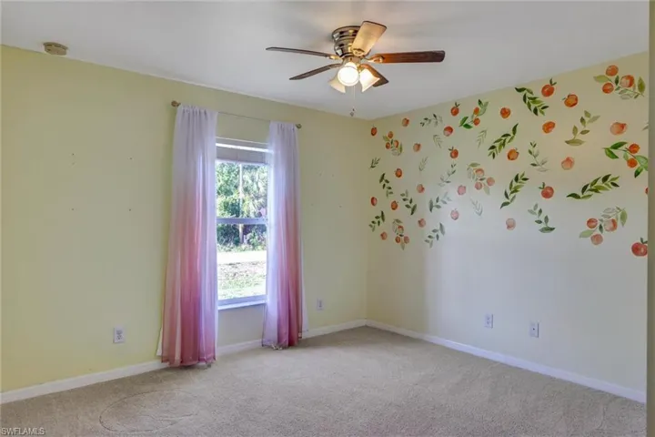 Unfurnished room featuring light carpet and ceiling fan
