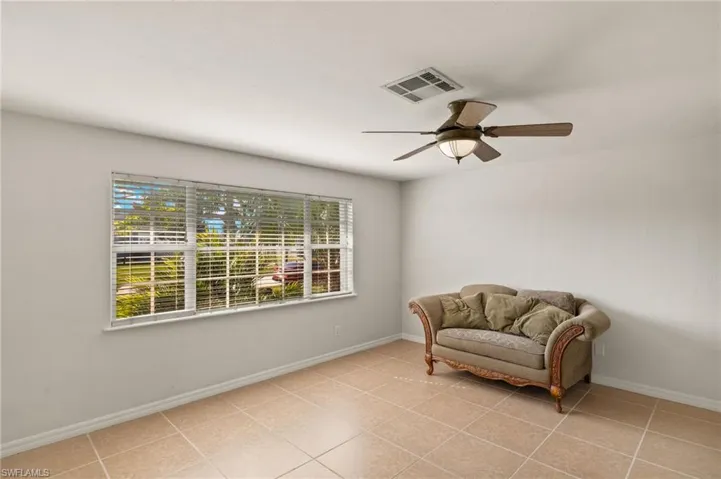 Sitting room with light tile patterned floors, a wealth of natural light, and ceiling fan
