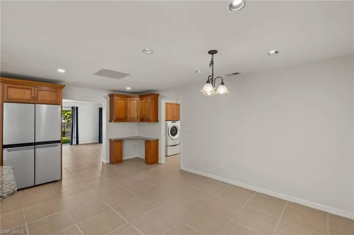 Kitchen with granite countertops, backsplash, stainless steel appliances, sink, and pendant lighting
