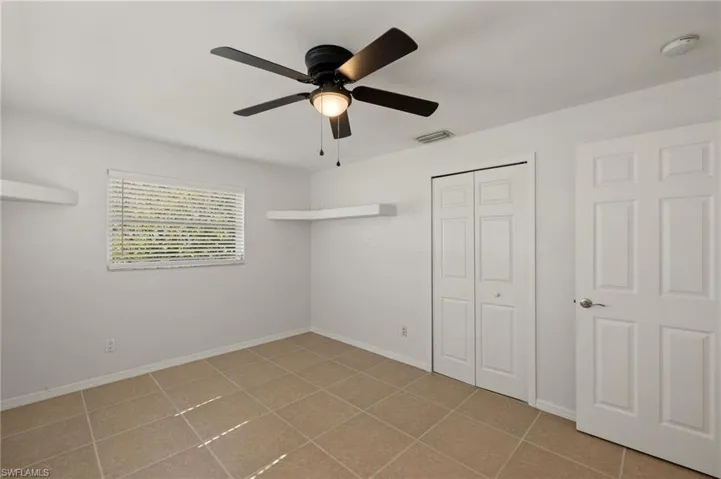 1st bedroom featuring ceiling fan and a closet