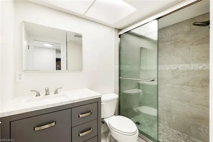 Guest Bathroom with a Step In Tiled Shower, Glass Sliding Doors, New Cabinetry, Mirrors, Water Closet