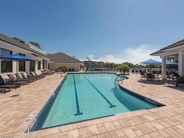 Rectangular swimming pool with lane markers, surrounded by an extensive paver deck