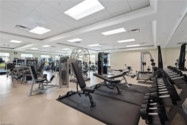 Spacious fitness center featuring various exercise equipment, recessed lighting, and ceiling fans