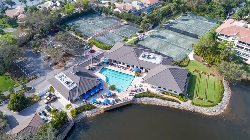Clubhouse with an outdoor swimming pool, multiple tennis courts, and bocce ball courts