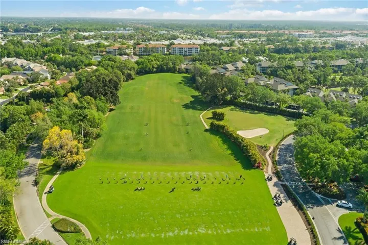 Expansive golf course with manicured greens, sand traps, and a driving range