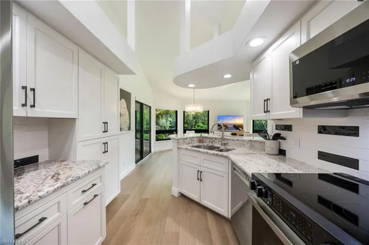 Kitchen featuring white cabinetry, light-toned wood-finish flooring, recessed lighting, and granite countertops