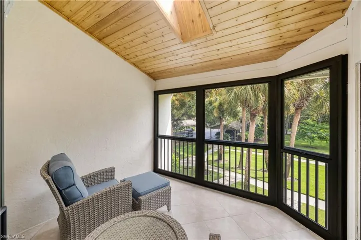 Screened outdoor area with a wood-planked ceiling, skylight, and tiled flooring