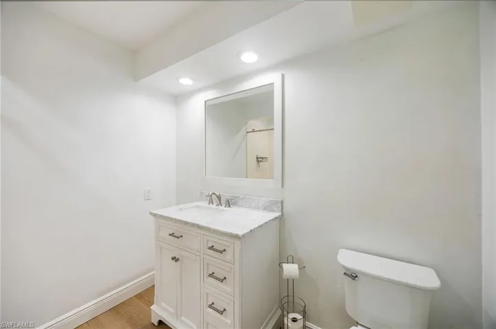 White vanity with shaker-style cabinetry, a white countertop, and a rectangular sink