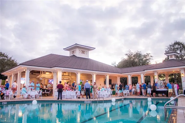 Outdoor pool area featuring a perimeter deck, a covered pavilion with white columns, and a central cupola structure