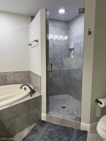 Full bath with a shower stall, a garden tub, and tile patterned floors
