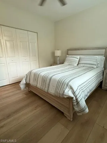 Bedroom featuring wood finished floors, a closet, and a ceiling fan