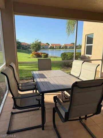 View of patio / terrace featuring outdoor dining area, a water view, and a sunroom