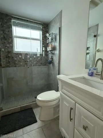 Bathroom with vanity, a shower stall, and light tile patterned floors