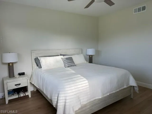 Bedroom with dark wood-style floors and a ceiling fan