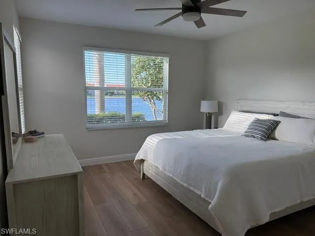 Bedroom featuring a water view, wood finished floors, and a ceiling fan