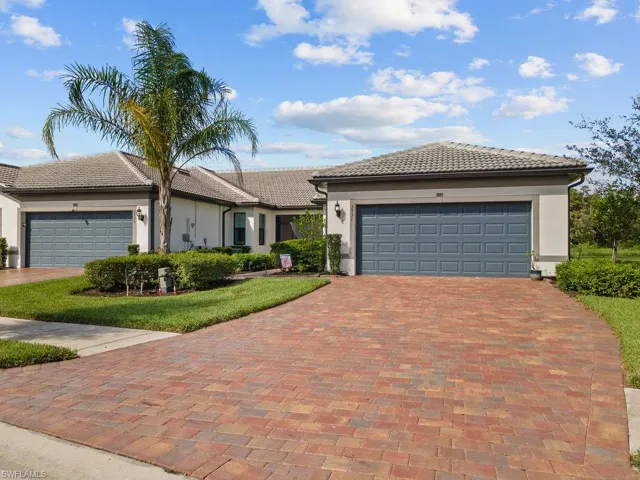View of front of house featuring stucco siding, decorative driveway, a garage, and a tiled roof