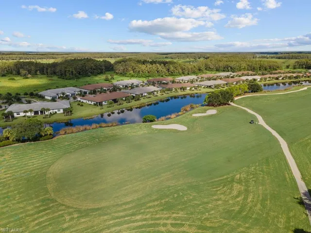 Aerial view of residential area with a golf course and a nearby body of water