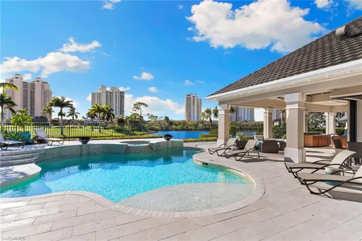 Integrated pool / hot tub featuring a patio area and a water view