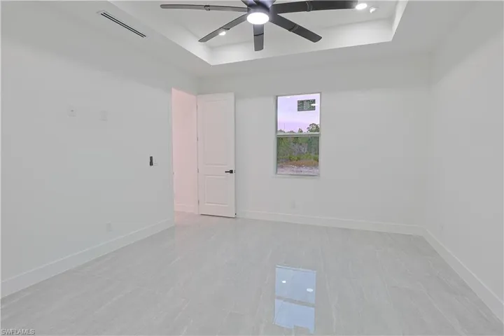 Unfurnished room featuring a tray ceiling, a ceiling fan, and recessed lighting