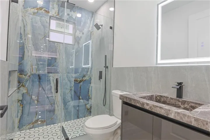 Full bathroom with vanity and a marble finish shower