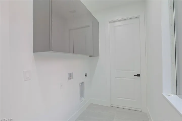 Laundry room with cabinet space, hookup for a washing machine, and hookup for an electric dryer