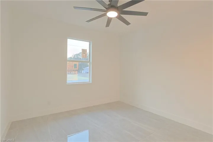 Empty room featuring ceiling fan and light tile patterned flooring