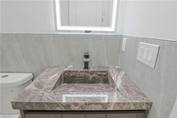 Half bathroom with vanity and toilet