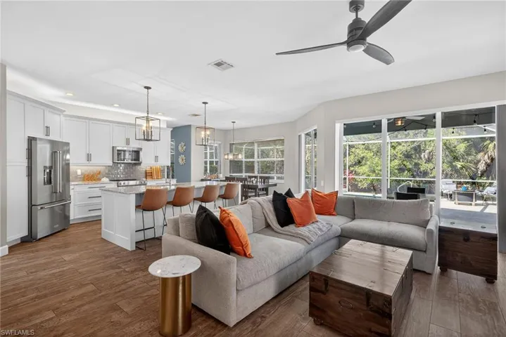 Living room featuring dark wood-type flooring, recessed lighting, a sunroom, and ceiling fan