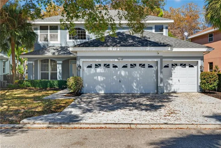 Traditional-style house with concrete driveway, an attached garage, stucco siding, and roof with shingles