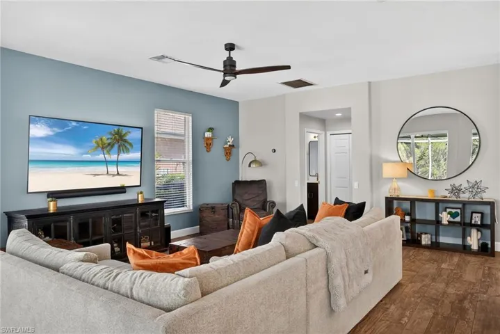 Living room featuring dark wood-type flooring and ceiling fan