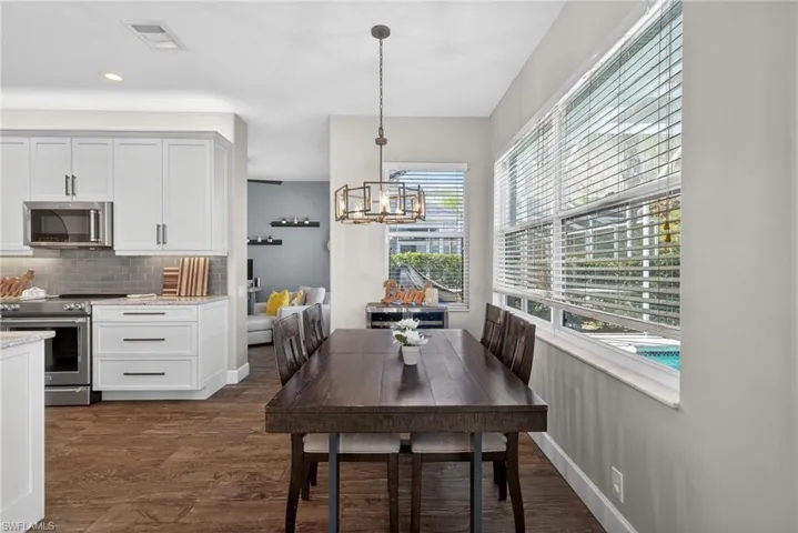 Dining space with dark wood-style floors and a chandelier