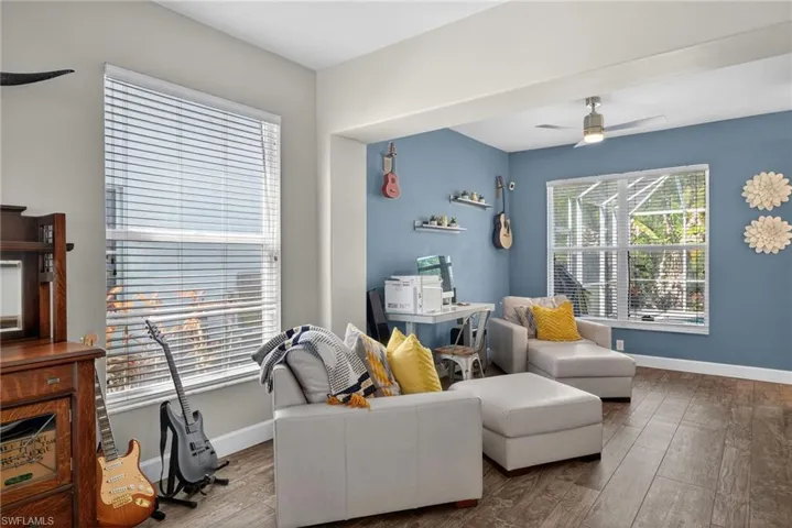 Den featuring wood-type flooring and ceiling fan