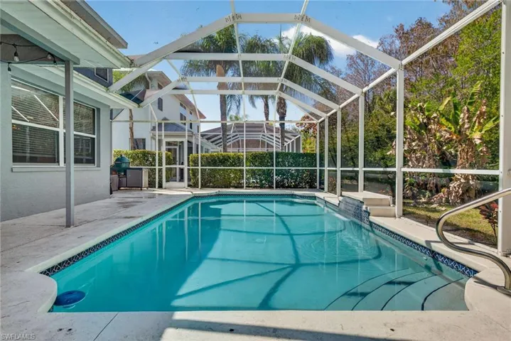 View of pool with patio surround, a sunroom, and a lanai